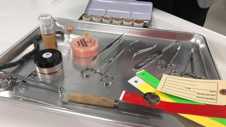 Dans un laboratoire, des instruments de thanatopraxie (ciseaux-couteaux-baume) déposés sur un plateau