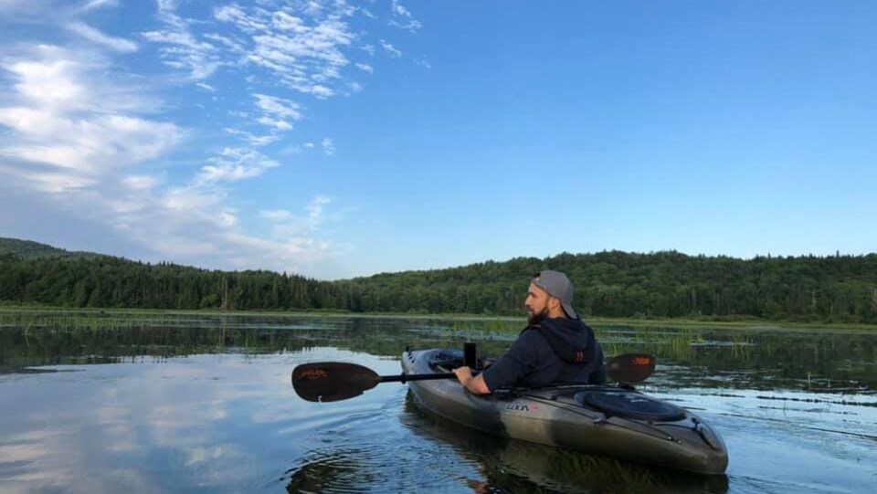 Sur un lac, un homme pratique le kayak
