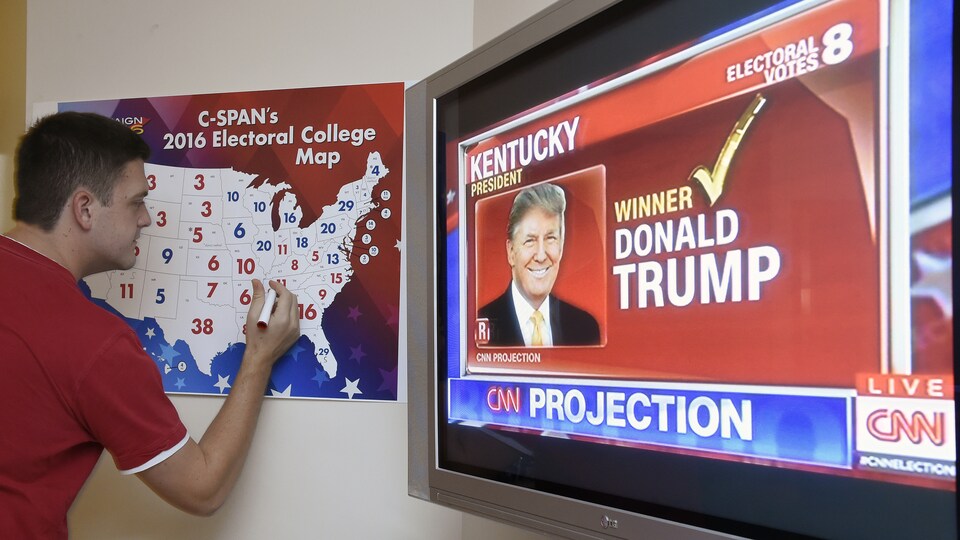 Un homme annote une carte électorale des États-Unis accrochée au mur lors des élections américaines du 8 novembre 2016.