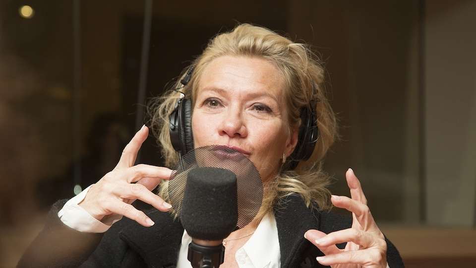 Élise Guilbault devant un micro dans un studio de radio.