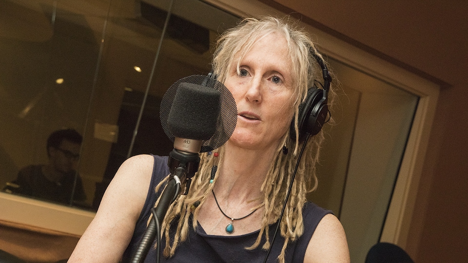 Ève Lamont devant un micro lors d'une entrevue à la radio de Radio-Canada.