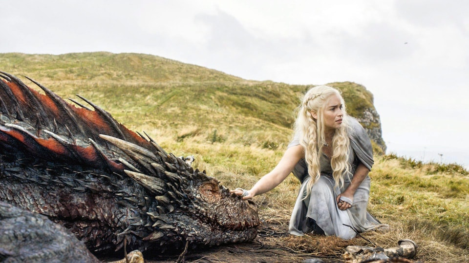 L'actrice Emilia Clarke touche un dragon une scène de la série <i>Game of Thrones</i>.