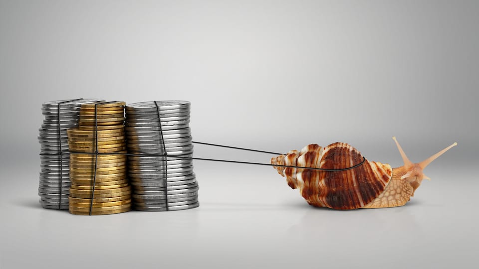 Un escargot tire trois piles de monnaie.