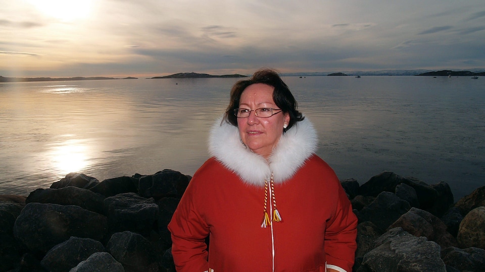 La militante écologiste Sheila Watt-Cloutier devant un lac et un coucher de soleil à Iqualuit, en 2007.
