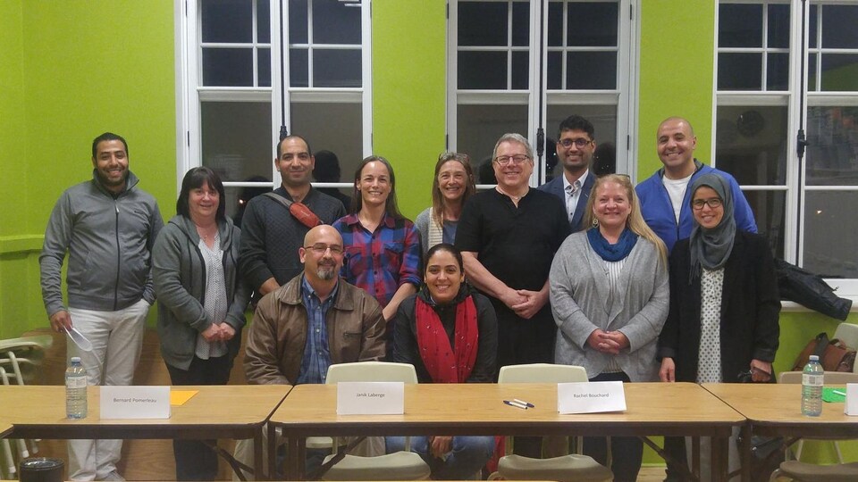 Un groupe d'hommes et de femmes souriants.