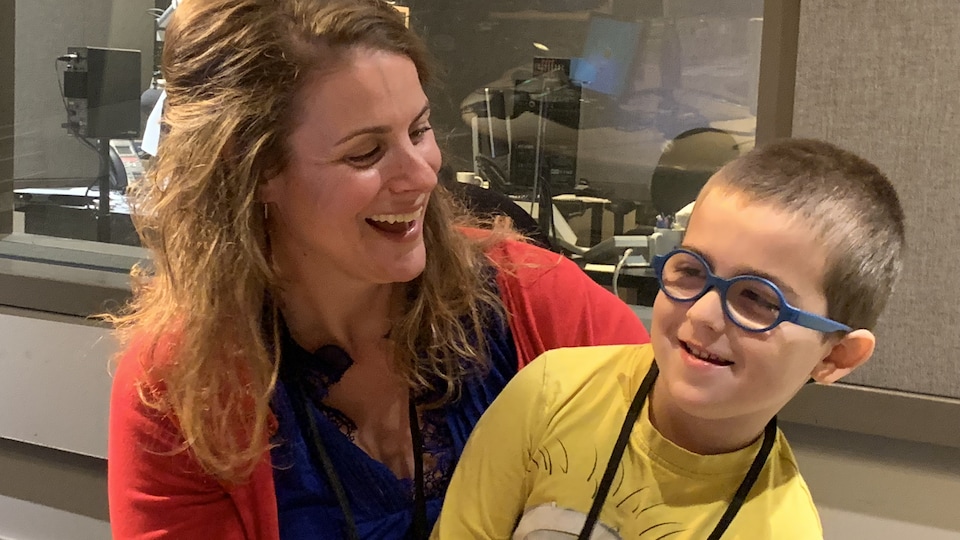 Une femme et un enfants dans un studio radio de Radio-Canada