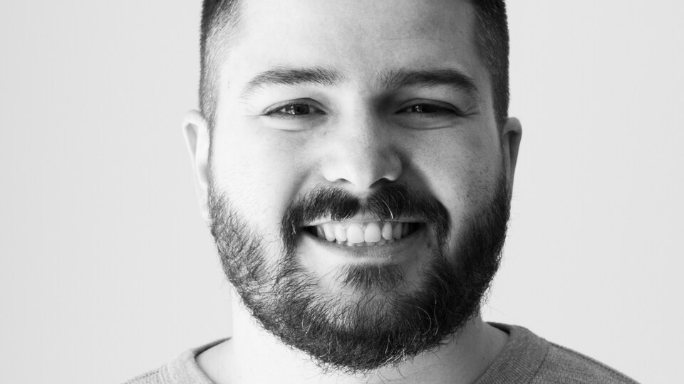 Nicolas Beique souriant à la caméra.