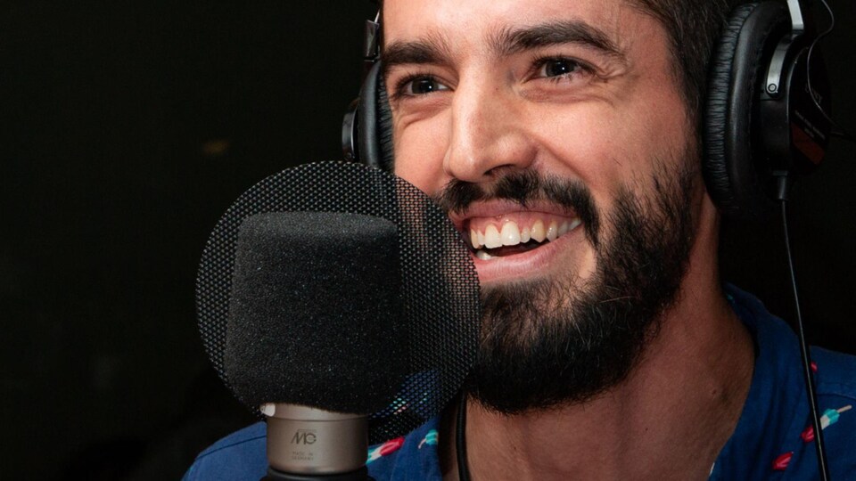 L'homme barbu sourit à belles dents.