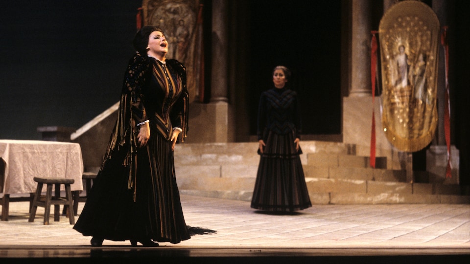 La soprano Nicole Lorange en costume d'époque chante sur scène.  