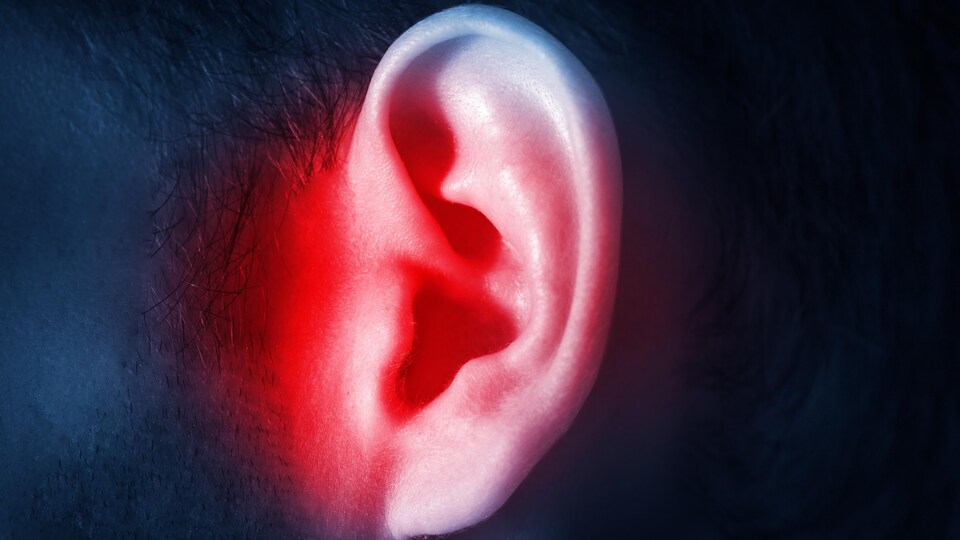 Une oreille d'un homme qui est aux prises avec un acouphène.