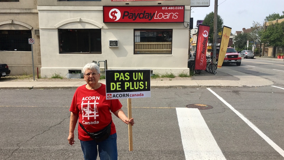 Une femme sur un trottoir avec une pancarte