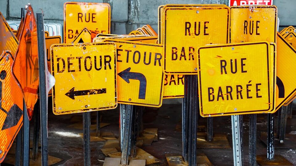 Des pancartes oranges empilées dans un hangar.