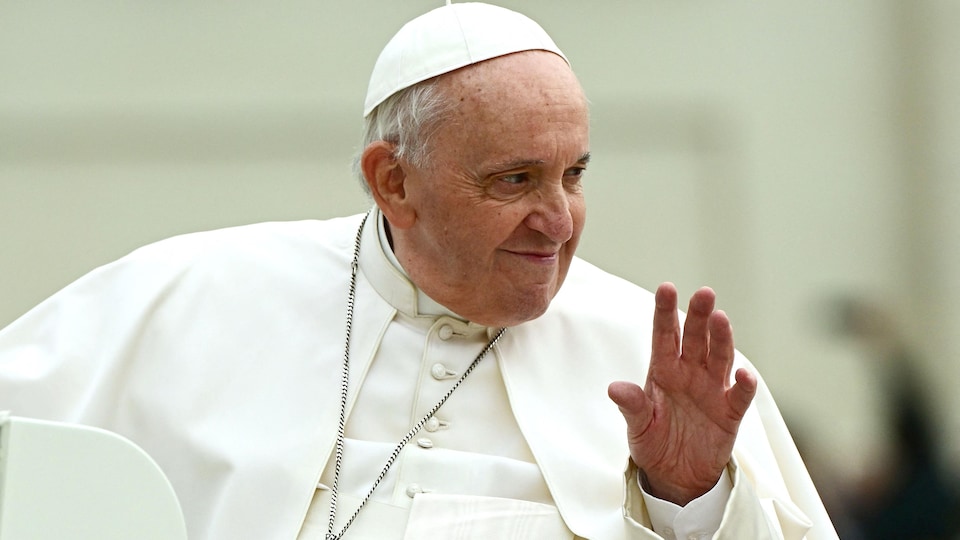Gros plan sur le pape François qui salue des gens à son arrivée pour l'audience générale hebdomadaire sur la place Saint-Pierre, au Vatican, le 4 mai 2022.