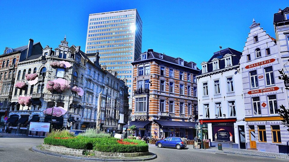 Les édifices historiques de pierre blanche bordent le rond point en pavé de la place.