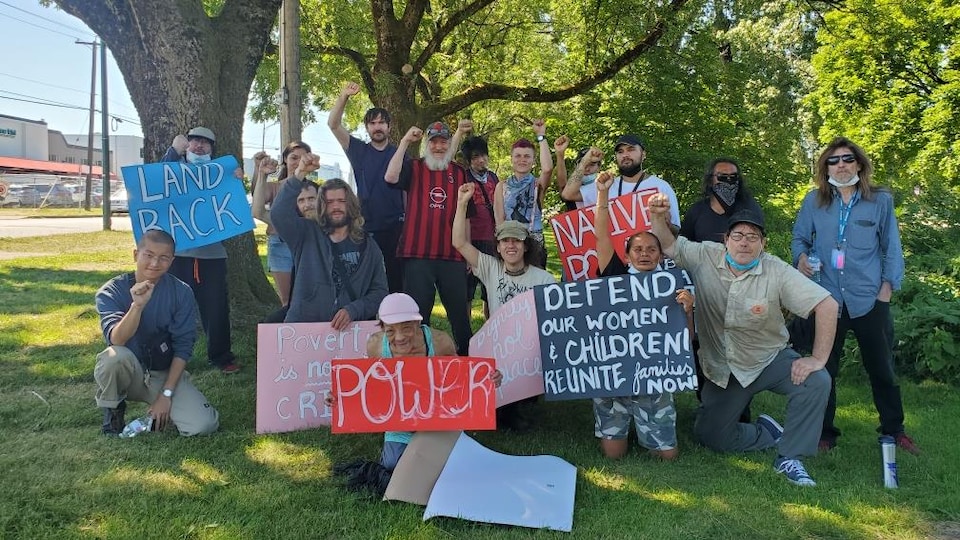 Des anciens résidents de Strathcona aux côtés de membres de VANDU, WAHRS et Red Braid Alliance ont le point dans les airs avec des affiches.