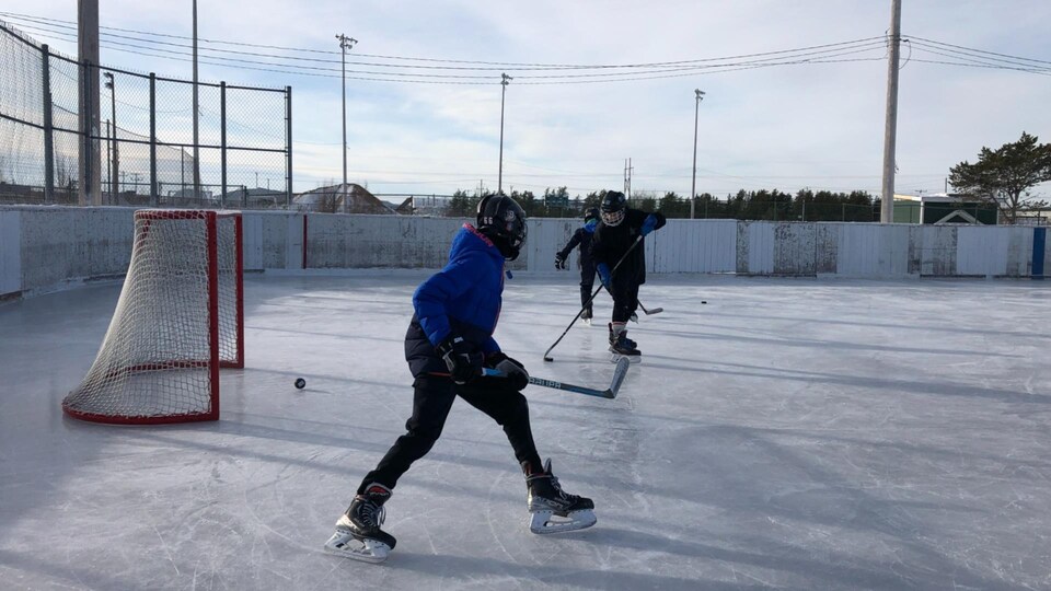 Des joueurs de hockey sur une patinoire à Sept-Îles.