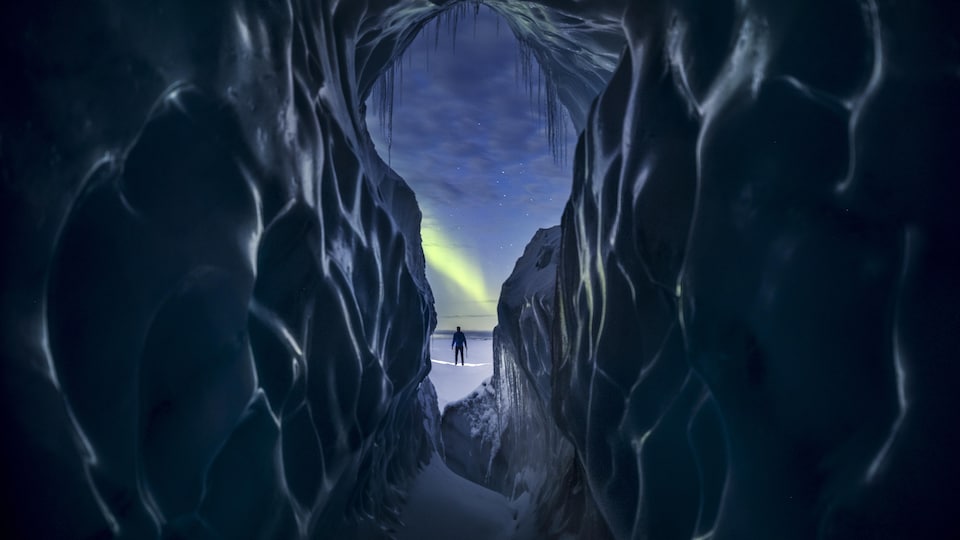 Un homme se tient entre des murs de glace.