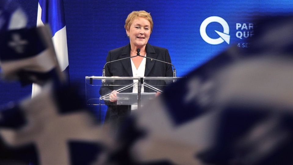 Pauline Marois, devant un lutrin et des drapeaux du Québec, lors d'un discours de victoire le 4 septembre 2012.