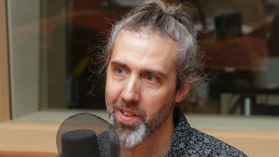 Photo de Dany Bouchard devant un micro de radio.