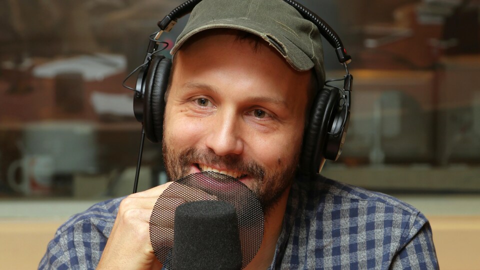 Photo d'Émile Proulx-Cloutier devant un micro de radio.