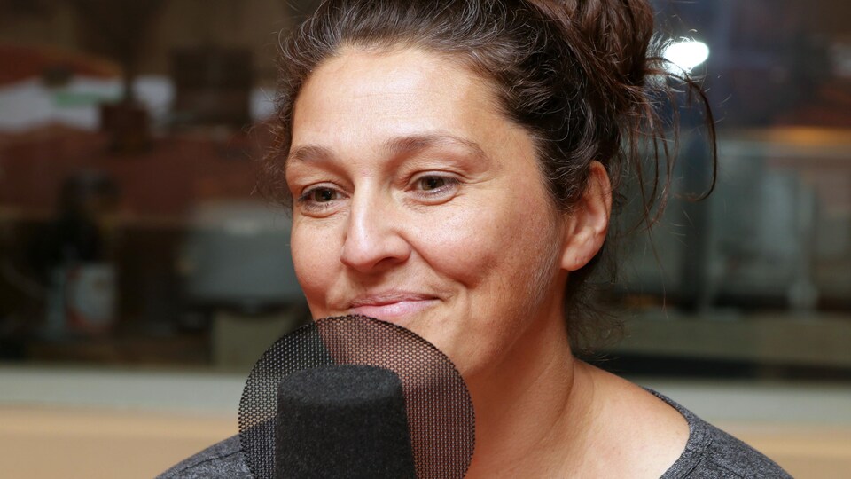 Photo de Fernande Ouellet devant un micro de radio.