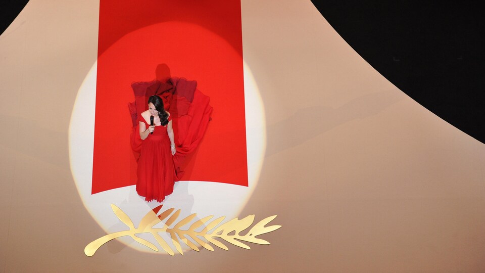 Vue aérienne de l'actrice sur le tapis rouge avec une palme d'or géante dans le sol.