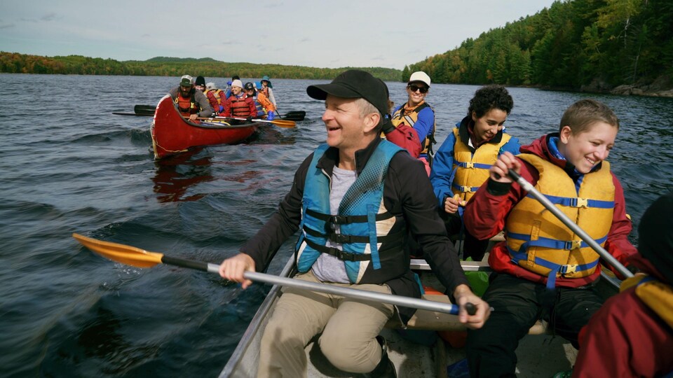 André Robitaille et des adolescents font du canot.