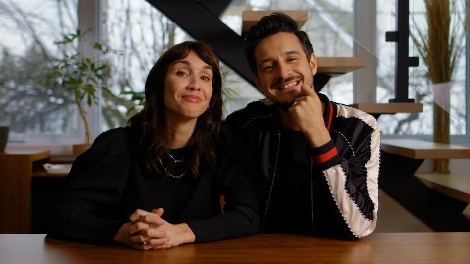 Le couple pose assis à une table.