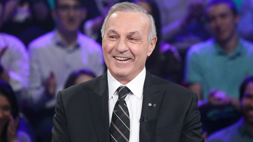 Guy Lafleur est souriant à la table des invités sur le plateau de Tout le monde en parle.