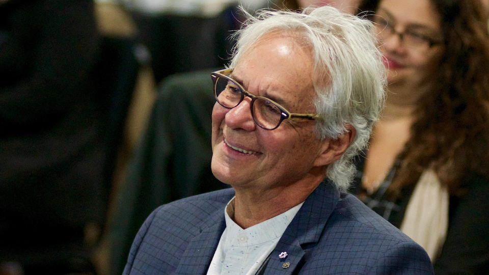 Portrait de lui souriant.
