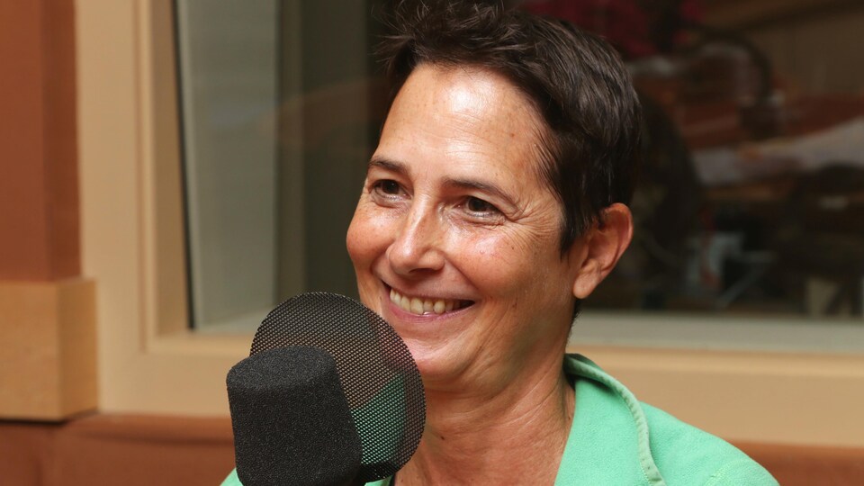 Photo d'Hélène Cyr devant un micro de radio.