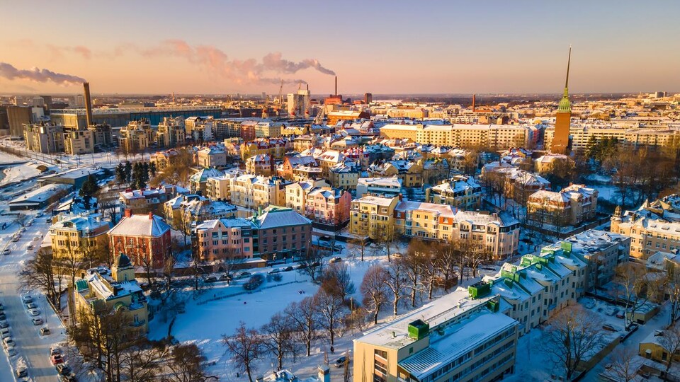 Vue aérienne sur un quartier de petits immeubles de quatre étages recouvert de neige.