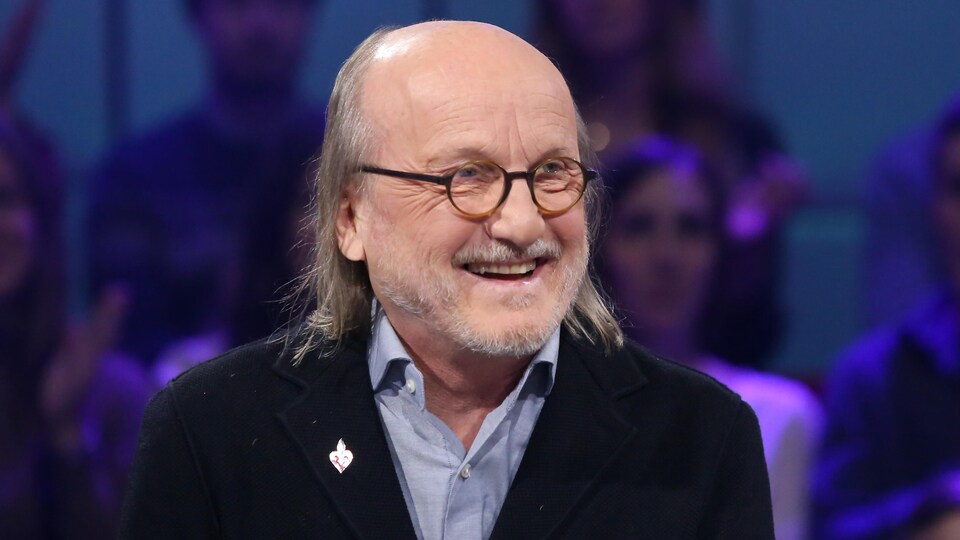 Il sourit sur le plateau de l'émission de télévision Tout le monde en parle.