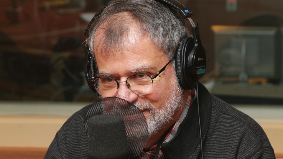 Photo de Martin Winckler devant un micro de radio.