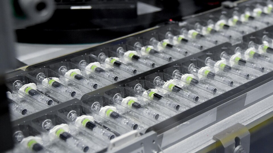 Des seringues vides sur une ligne de production dans une usine.