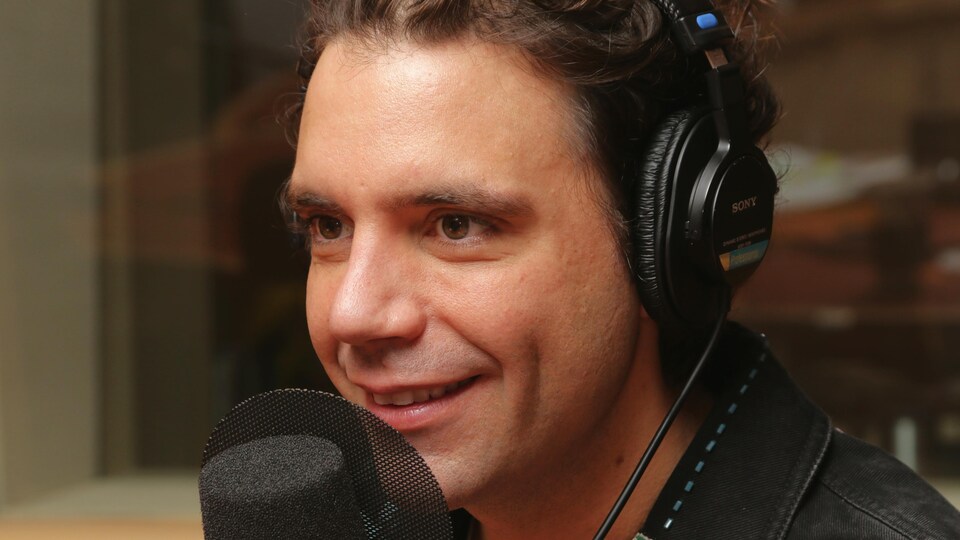 Photo de Mika devant un micro de radio.