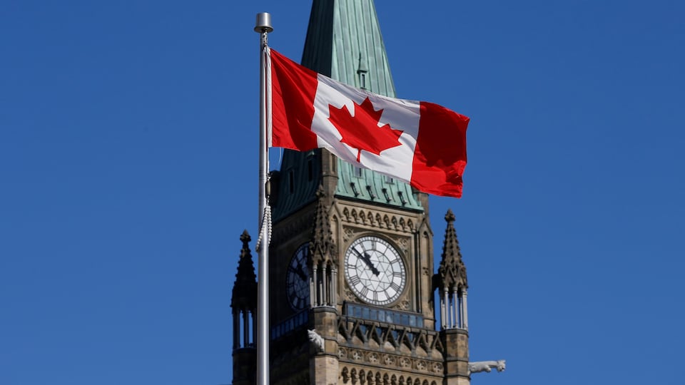 Un drapeau canadien flotte devant la tour.