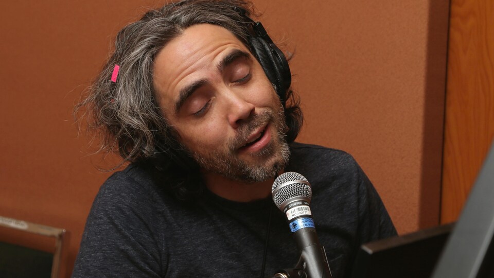 Photo de Patrick Watson, les yeux fermés, qui joue au piano et chante dans un micro.