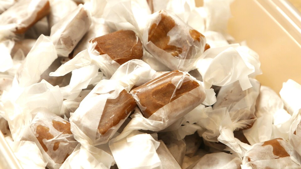 Des bonbons enveloppés dans une boîte en plastique.