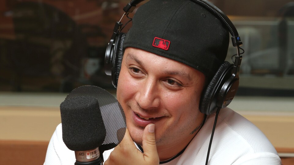 Photo de Samian devant un micro de radio.