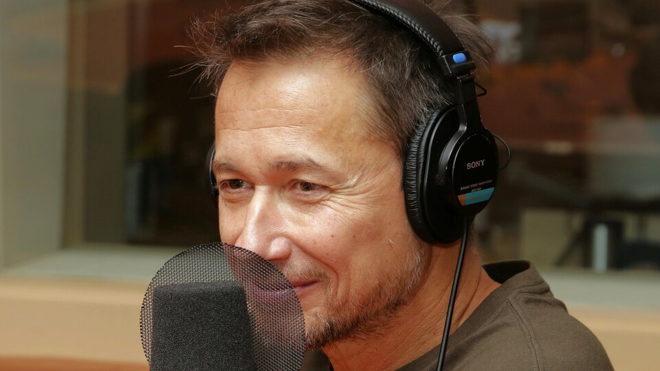Photo de Stéphane Rousseau devant un micro de radio.
