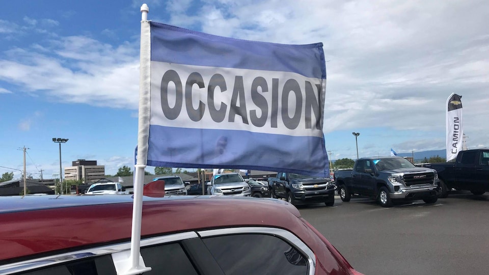 Un drapeau disant « occasion » accroché à la fenêtre d'un véhicule.