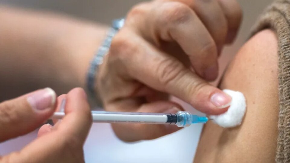 Un professionnel de la santé administre un vaccin à un patient. 