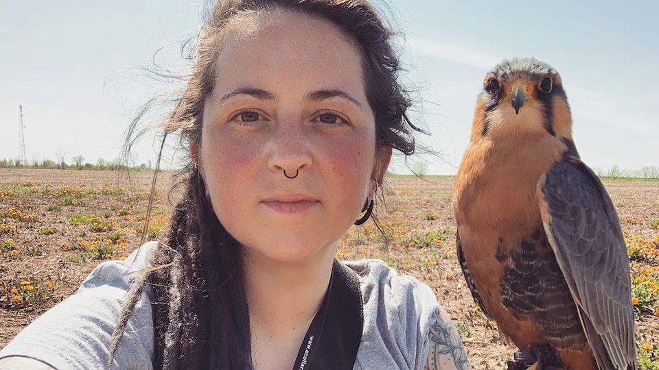 Selfie d'une femme avec son faucon perché sur sa main.