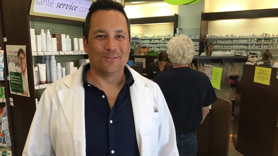 Le pharmacien-propriétaire du Proxim centre-ville Rouyn-Noranda, Sébastien Côté, devant le comptoir-caisse de son commerce.