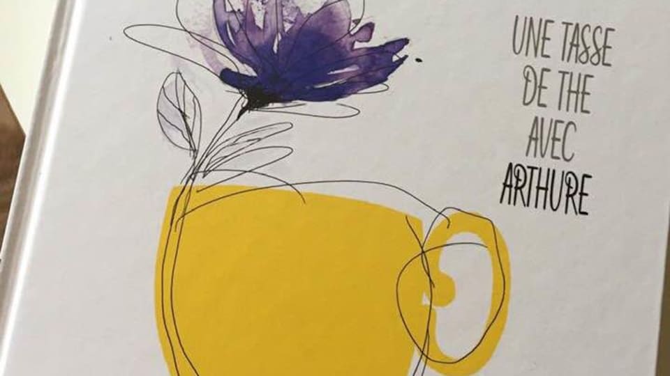 Le livre Une tasse de thé avec Arthure sur lequel est dessiné une tasse avec une fleur.