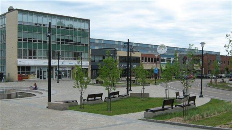 La Place La Salle à Baie-Comeau : un lieu avec une fontaine, des bancs, des arbres et des commerces.