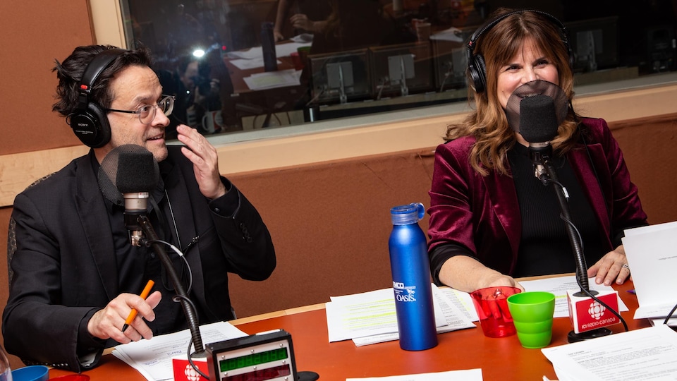 Les deux comédiens sourient autour de la table de l'émission.