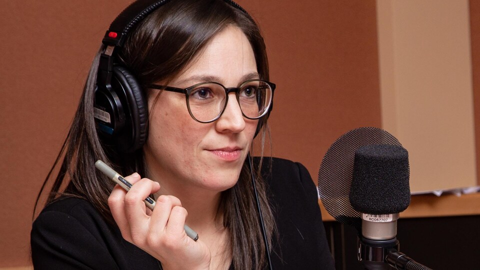 La jeune femme à lunettes écoute l'animatrice.