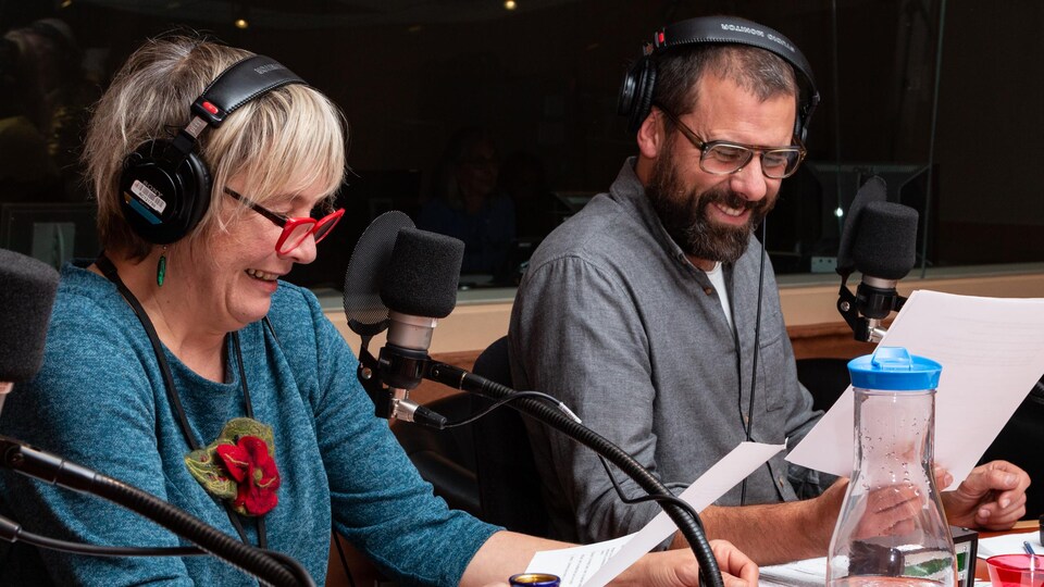 Les deux comédiens sourient en lisant leur feuille.